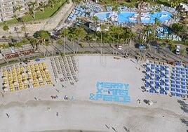 Anfi felicita la Navidad con un mensaje formado por cientos de toallas desde la playa
